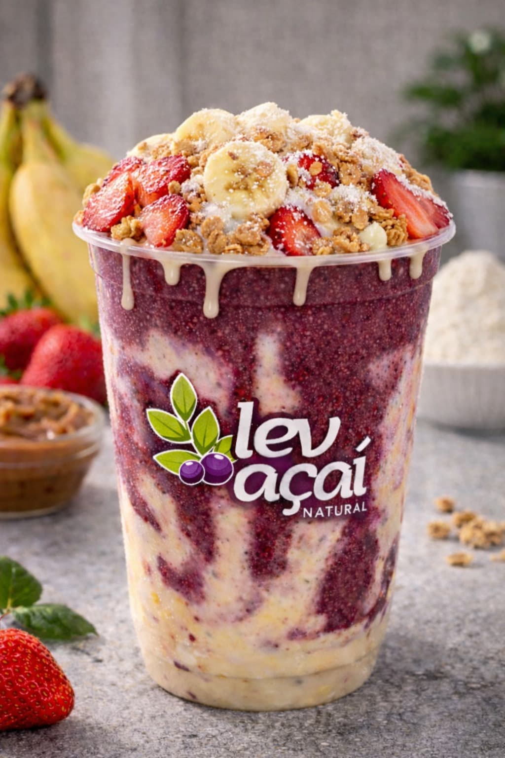 A LEV açaí cup piled with strawberries, banana and a drizzle of condensed milk